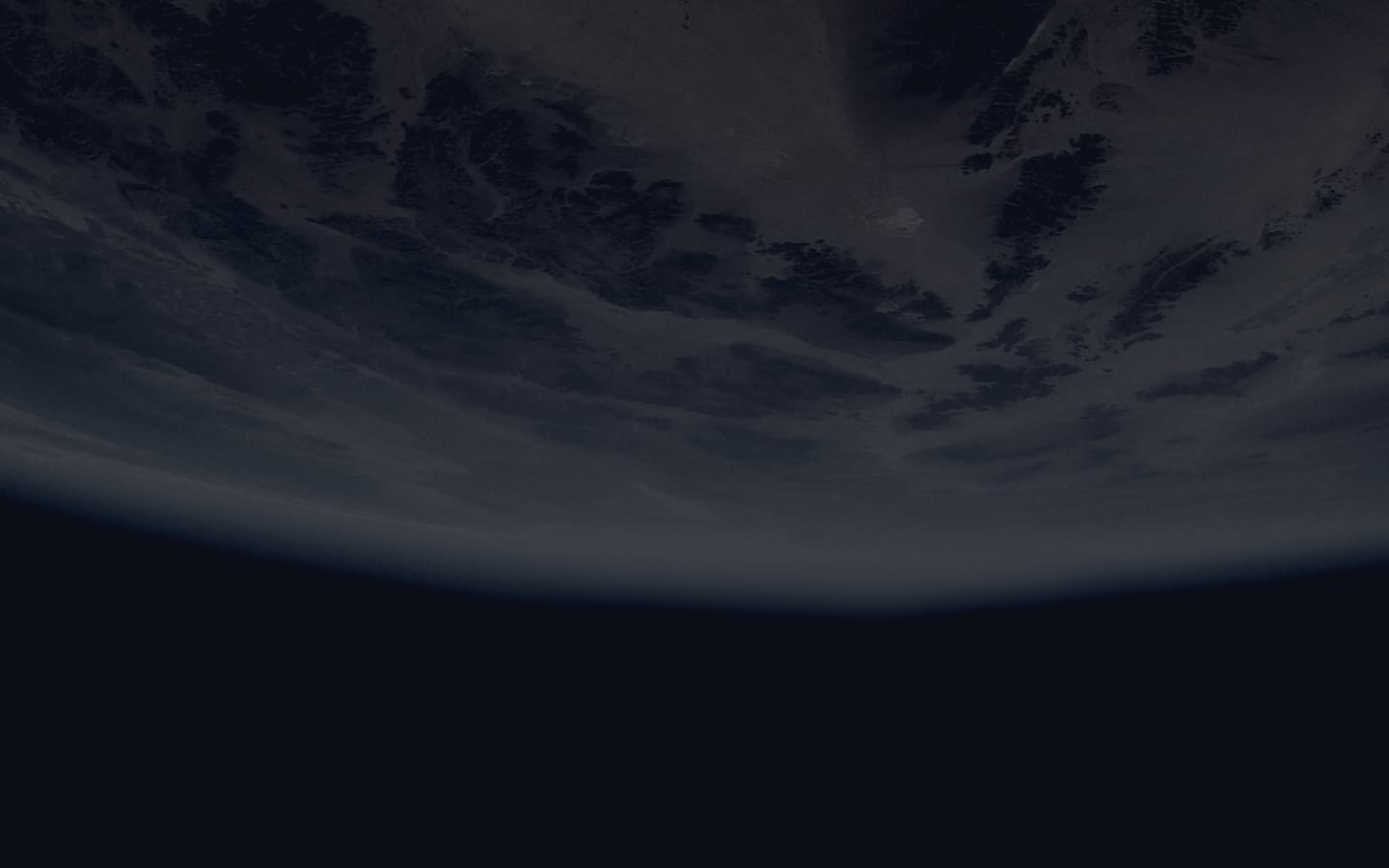 A partially illuminated Earth with visible continents and cloud cover.