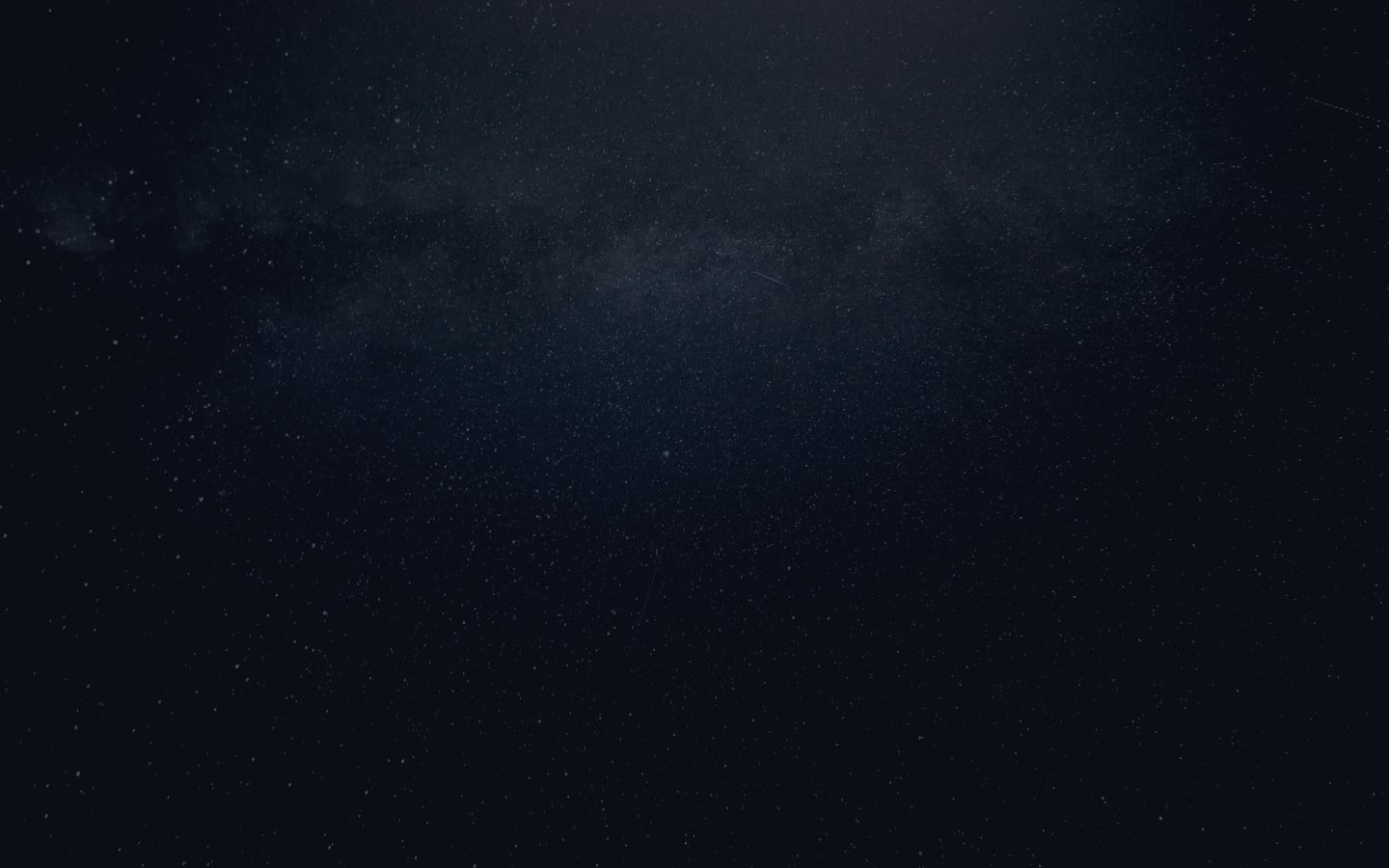 A night sky filled with stars, with the Milky Way galaxy visible as a faint band across the center.
